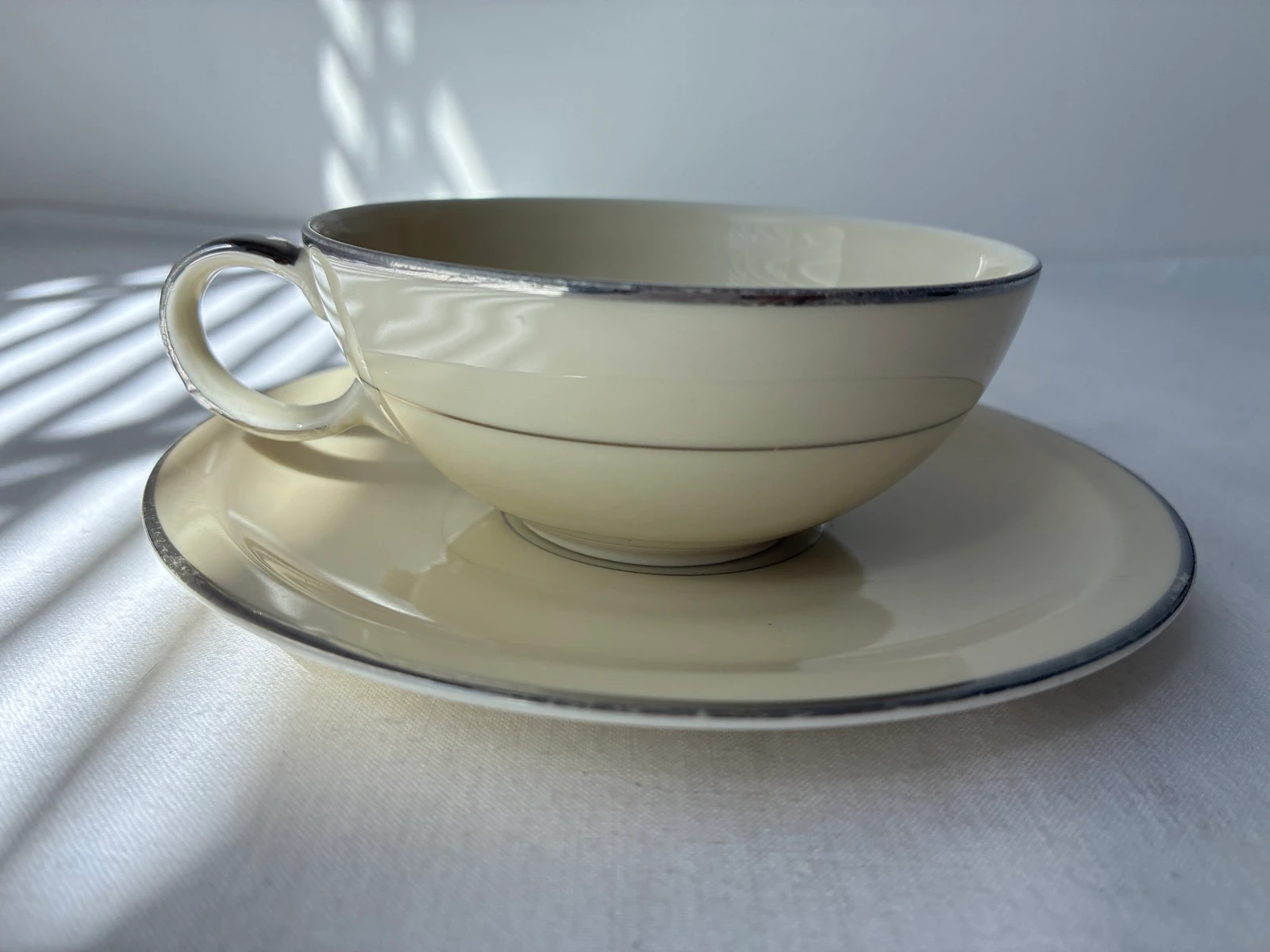 Elegante Vintage Kop en Schotel – Gebroken Wit met Zilveren Rand